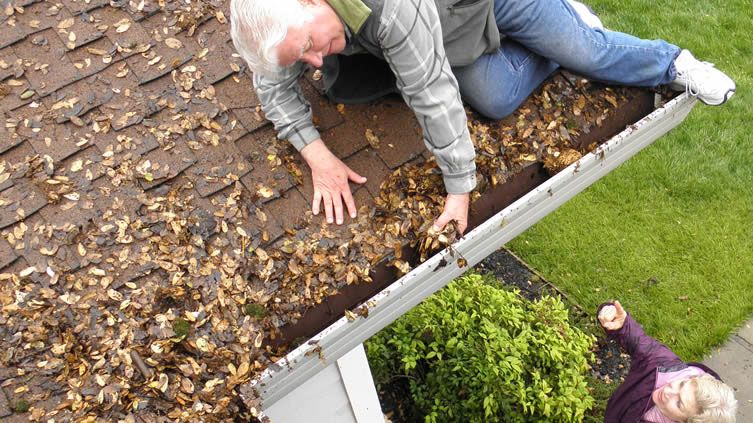 old man cleaning gutters